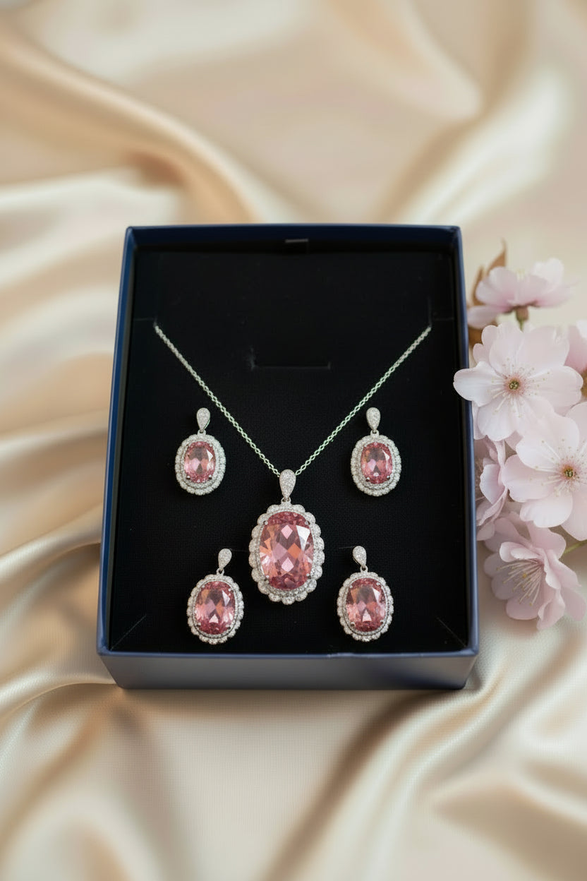 Jewelry set with pink gemstones including necklace, earrings, and ring on a dark background.