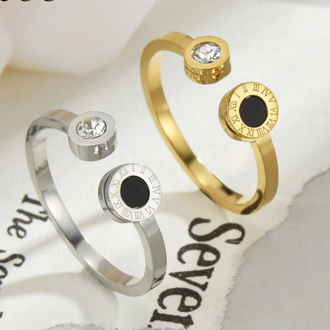 Two gold and silver rings with black stones on a white background with 'Free Teeme' branding.